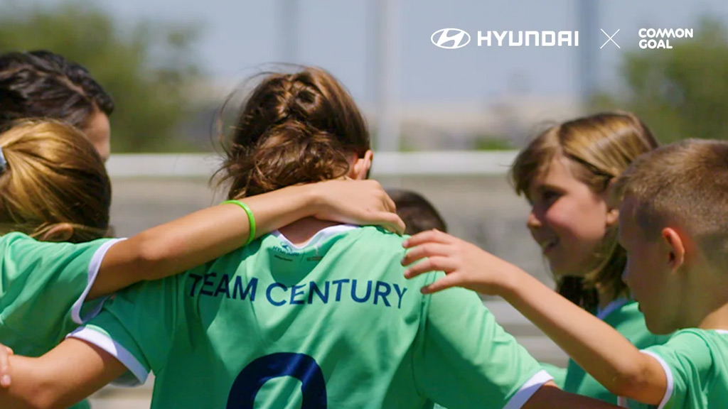 Niñas abrazandose con camisetas de goal century dentro de un partido de soccer