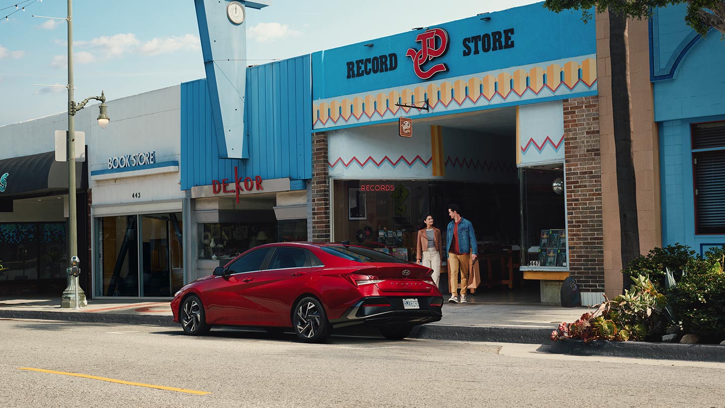 Nuevo Elantra 2024 en color rojo, afuera de una record store