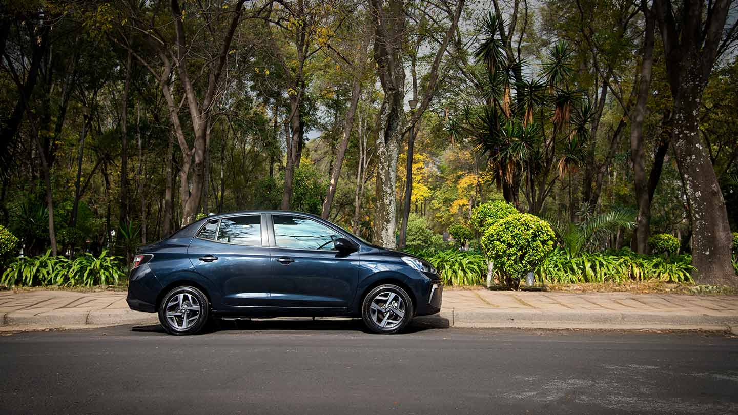 Hyundai Grand i10 Sedán color azul estacionado junto a un parque