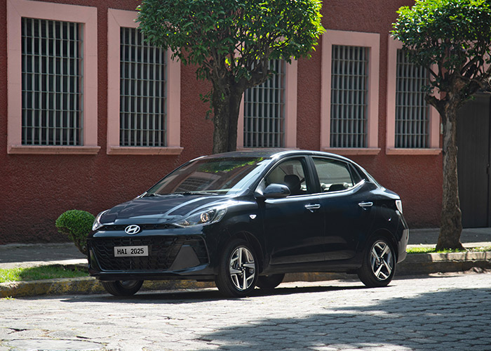 Hyundai Grand i10 Sedán color azul estacionado afuera de casa estilo colonial